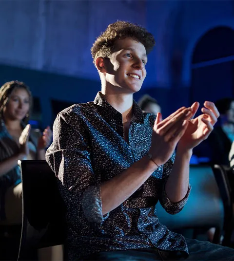 A person clapping their hands at an event