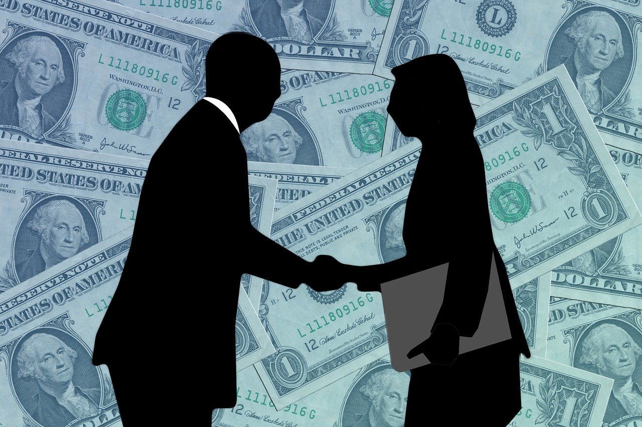 Man and women shaking hands to complete deal